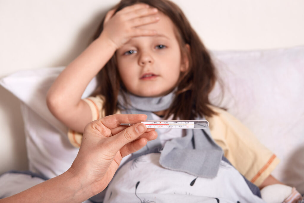 Niña con fiebre mala en la cama